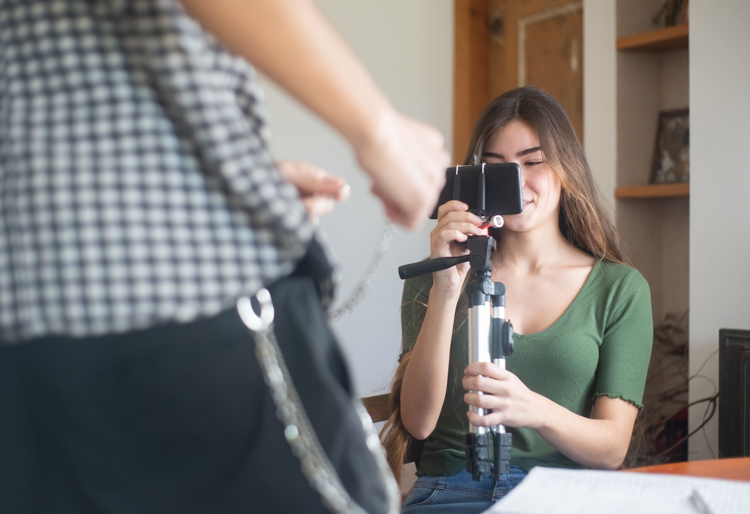 Frau nimmt mit einem Smartphone auf einem Stativ ein Video für soziale Netzwerke auf