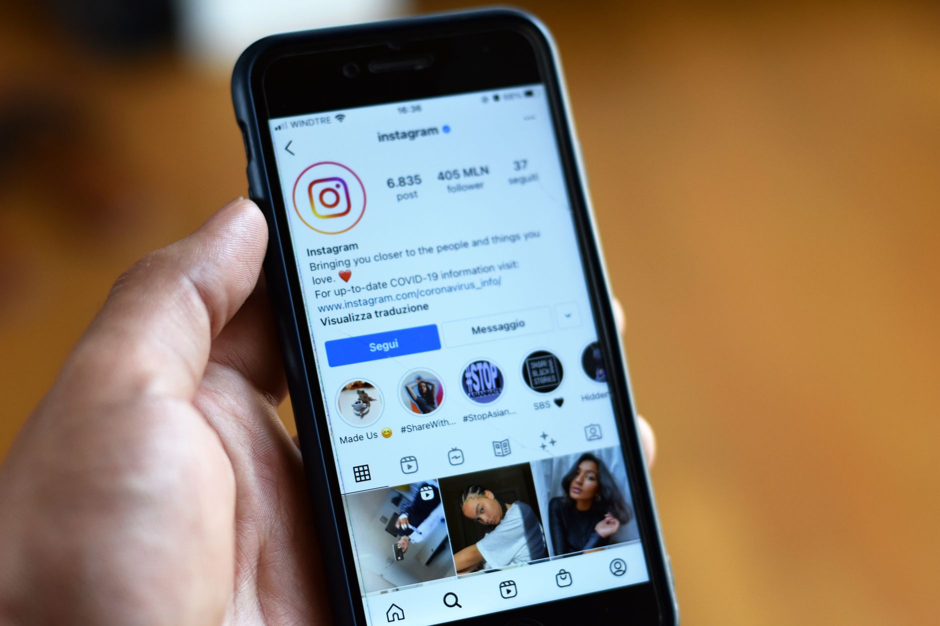 Hand hält ein Smartphone mit einem geöffneten Instagram-Profil eines Unternehmens